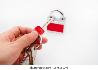 hand hold a key with red sticker which is the same color of padlock , mistake proofing or poka yoke concept as symbol for remind to use the right key ,selective focus on the key - Shutterstock ID 1576181095