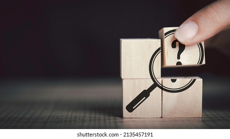  Hand hold magnifying glass and question mark sign icon in wooden cube. Problems and root cause analysis concept. copy space for background or text.