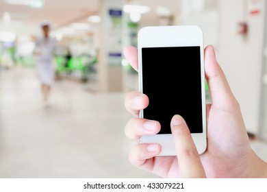 hand hold mobile smartphone with hospital interior blur medical background - Powered by Shutterstock