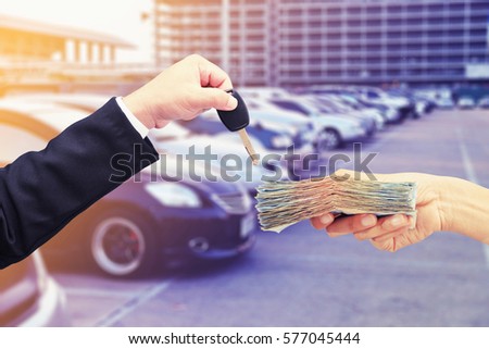 hand hold money and key car , buy or rent concept