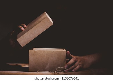 Hand Hold And Open A Mysterious Box On Wooden Table