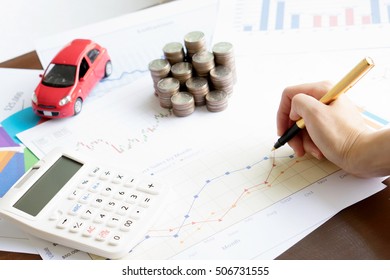 Hand hold a pen and press calculator and toy car and coins and business chart with sun lights color tone backgrounds
