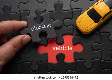 Hand Hold Piece Of Puzzle Written ELECTRIC Revealing Word VEHICLE