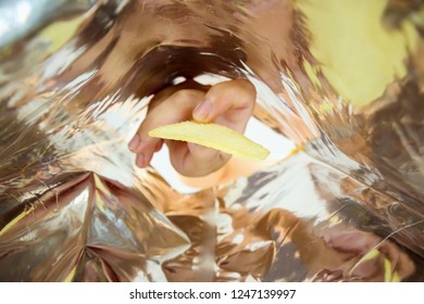 Hand Hold Potato Chips Inside Snack Foil Bag