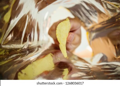 Hand Hold Potato Chips Inside Snack Foil Bag