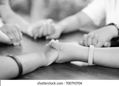 Hand hold Praying family. Father Mother daughter and son holding hand and pray in the table. black.