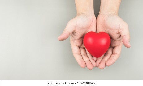 Hand Hold Red Heart On White Background. Concept Donation Helps Find Loving Health Care Equity And Promote Well Being. Top View. Gift For You  Copy Space.