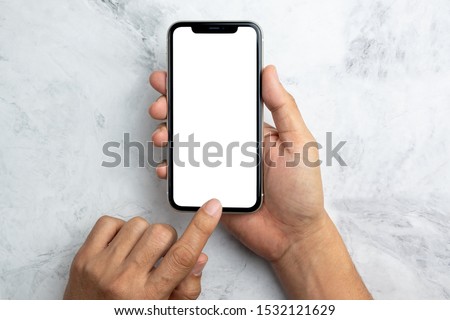 Hand hold a smart phone white screen view from top on marble background