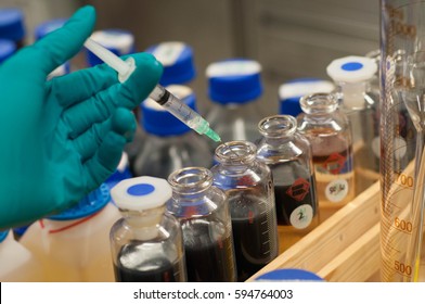 Hand Hold Syringes And The Crude Oil Sample Bottle.selective Focus