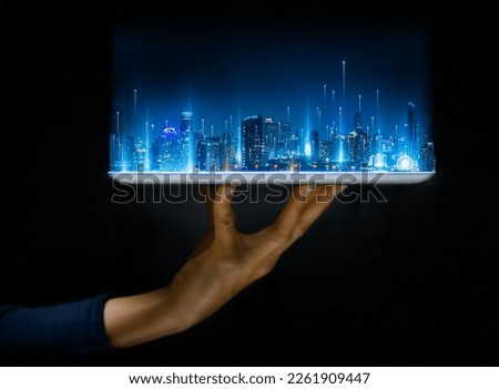 Hand hold tablet for build and make your smart city. Cityscape intelligent building, Futuristic urban hologram screen in concept of virtual internet of things and global network connection technology.