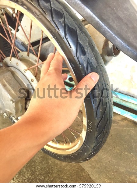 A hand hold tire for check tire\
pressure motorcycle.closeup.