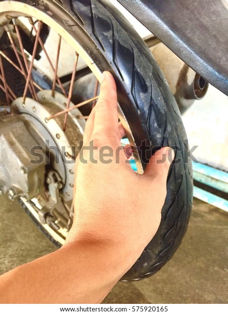 A hand hold tire for check tire\
pressure motorcycle.closeup.