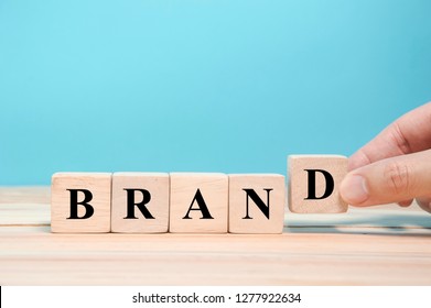 Hand Hold Wood Block To Complete The Word Brand, As Brand Management Concept