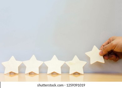 Hand hold Wood block five star shape on wooden table gray background. Block 5 stars rated best service excellence concept. Excellence customer vote quality satisfaction winners award. - Shutterstock ID 1259391019
