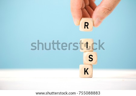 Hand hold wooden cubes with risk word. Risk management concept.