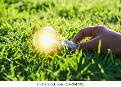 hand holdging light bulb on grass with solar energy. power eco concept - Shutterstock ID 1096847810
