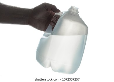 Hand Holding 1 Gallon Plastic Bottle Of Drinking Water; Silhouette On White.