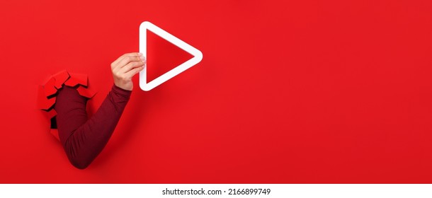 Hand Holding 3d Media Play Button Over Red Background, Panoramic Layout