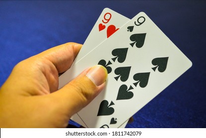 hand holding 9  spade and 9 heart card on baccarat game. playing cards .