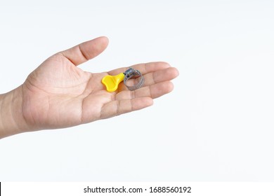Hand holding adjustable universal ring adapter for water hose tap connector pipe on white background