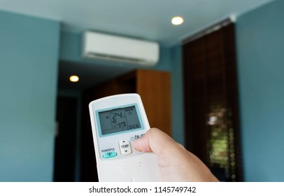 Hand Holding Air Conditioner Remote Controller In Room