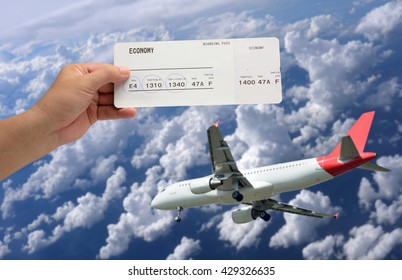 Hand Holding Airline Boarding Pass Ticket On Plane Was Landing And Sky-clouds Background.