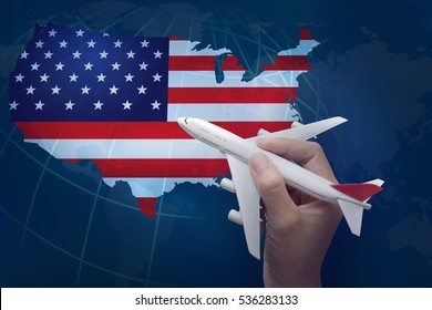 hand holding airplane with map of United States.