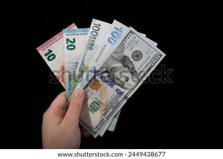Hand holding American dollar  banknotes isolated on black background