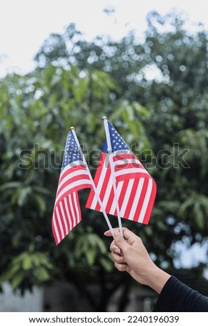 Hand holding american flag ooutdoors