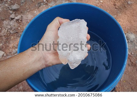 Hand holding Ammonium alum solid flocculant. 