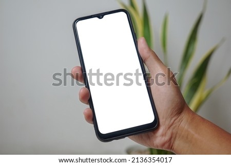 Hand holding android smartphone with blank white screen with clipping path
