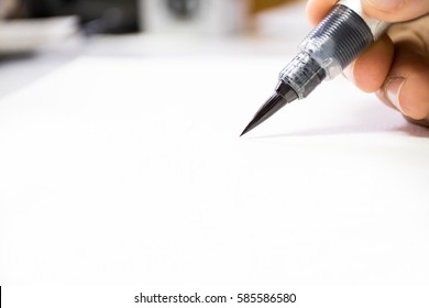 Hand holding art color brush closeup view on blurry focus. - Shutterstock ID 585586580