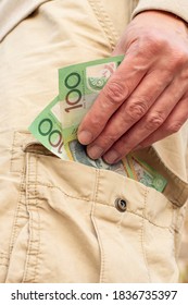 Hand Holding Australian Dollars 100 Banknotes In The Pocket Of Cargo Shorts. Tradie Finance Concept.