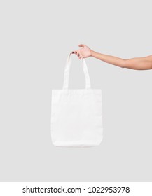 Hand Holding Bag Canvas Fabric For Mockup Blank Template Isolated On Gray Background. 