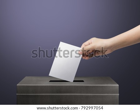 Hand holding ballot paper for election vote concept at place election background.