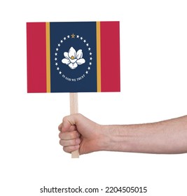 Hand Holding Banner On Wood Stick, Isolated - Flag Of Mississippi