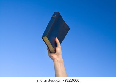 Hand Holding Bible Over Blue Sky