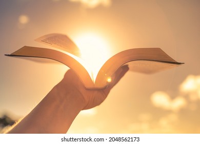 Hand Holding Bible Up To The Sun Light. 