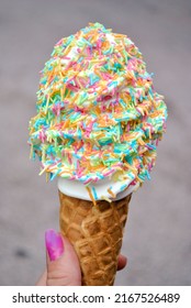 Hand Holding Big Sundae Ice Cream With Colorful Sprinkles During Summer Vacation.  