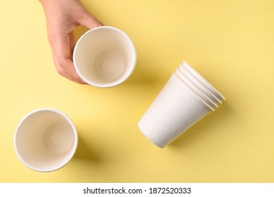 Hand Holding Biodegradable Coffee Cup On Yellow Background, Sustainable Concept