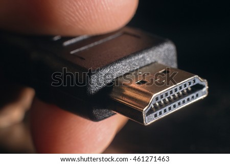 Hand holding black HDMI cable. Man's hand holds a HDMI Connector.
Closeup HDMI cable.Selective focus and shallow Depth of field.