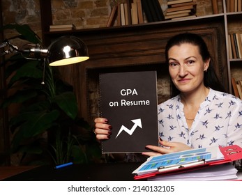 Hand holding black notepad with phrase grade point average GPA on Resume . Close-up shot.