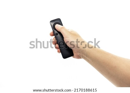 A hand holding a black simple fan remote
