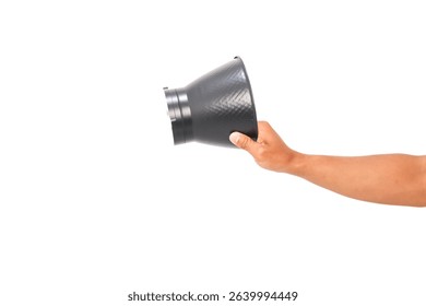 Hand holding a black speedlight snoot with a textured surface, photography equipment on a white background