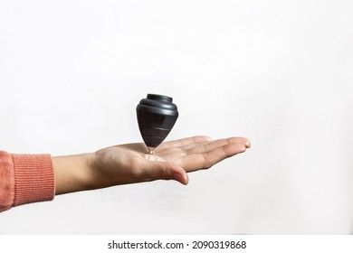 Hand Holding A Black Spinning Top, Kids Toy