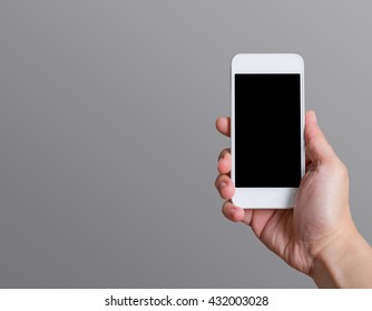 Hand holding blank black screen smart phone (mobile phone) at dark grey background,Mock up for display or montage of your content,Leave space at side of object to adding text