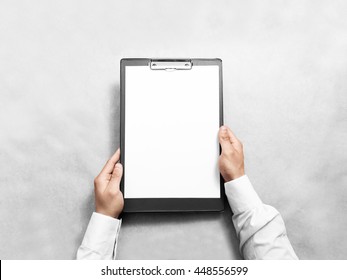 Hand holding blank clip board with white paper design mockup. Clear a4 document folder mock up template hold in arm. Clipboard notepad surface display front. Checklist tablet clamp file presentation.