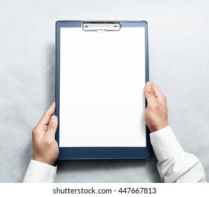 Hand holding blank clipboard with white a4 paper design mockup. Clear document holder mock up template hold arm. Clip board notepad surface display front. Checklist tablet plan file presentation.