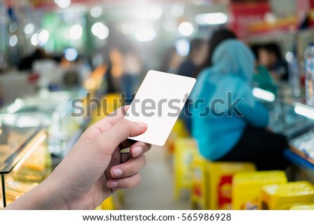 Hand holding blank credit card or ticket  at mall