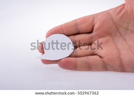 Hand holding a blank empty speech bubble made white paper
